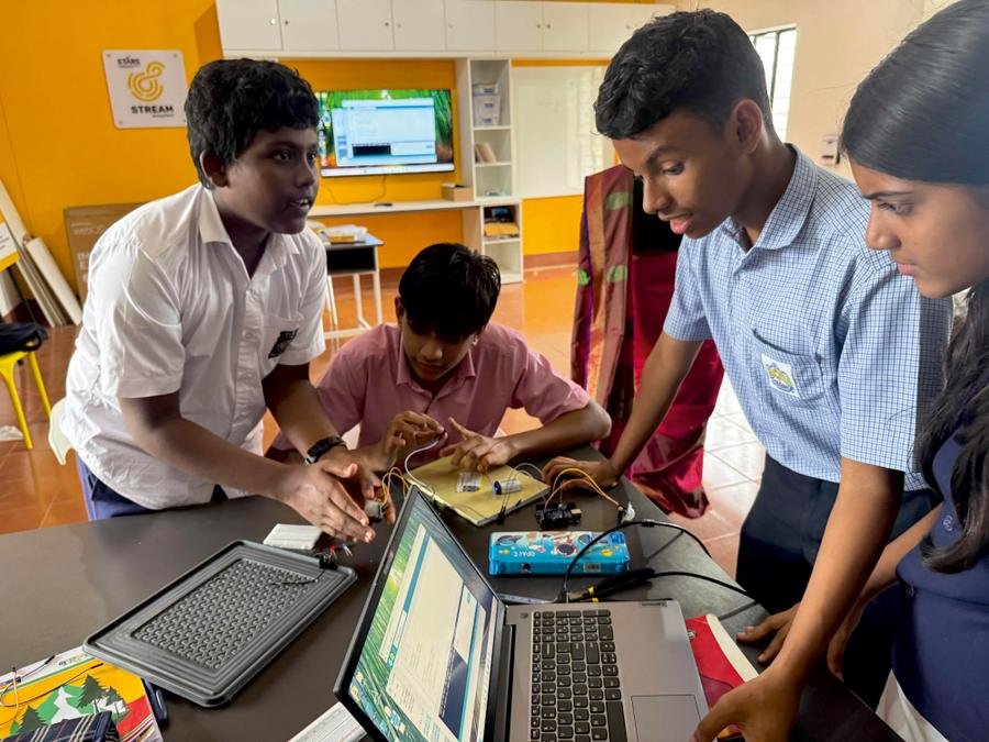 Students working on an electronics project with a laptop